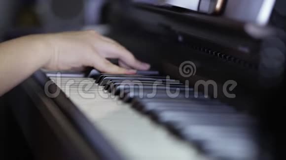 手少年女孩在数字钢琴的键盘上弹奏特写视频的预览图
