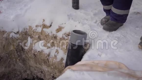 在冰冻的地面上挖沟的框架里钢和塑料制成的管道在沟槽中视频的预览图