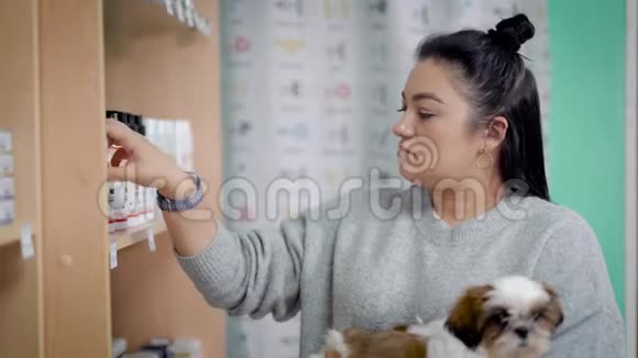年轻女人选择狗洗发水视频的预览图