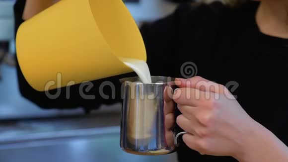 咖啡师慢慢地把牛奶倒入牛奶罐视频的预览图