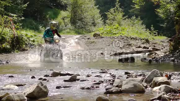 骑摩托车的人穿过山河视频的预览图