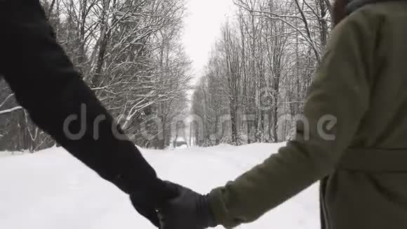 一对夫妇手牵着手在冬天走开慢动作视频的预览图