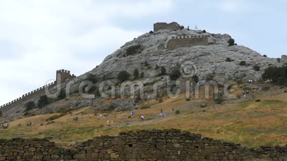 游客参观一座古老的中世纪堡垒的废墟视频的预览图