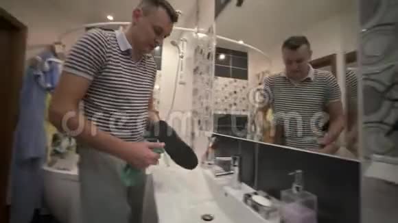 父亲打扫鞋子儿子帮助他这个男孩重复他父亲动作视频的预览图