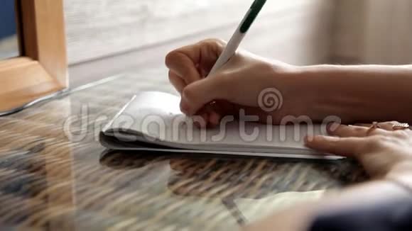 这个女孩正坐在家里在笔记本上做笔记我爱你视频的预览图