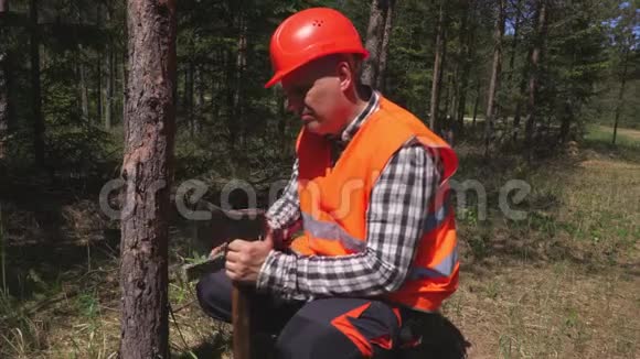 伐木工人在森林里磨斧子视频的预览图