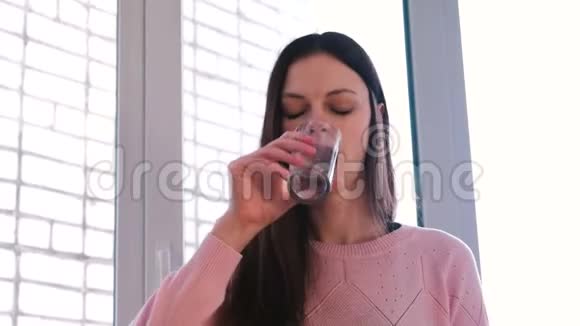 年轻女子急切地喝着杯子里的水然后把它洒在自己身上视频的预览图