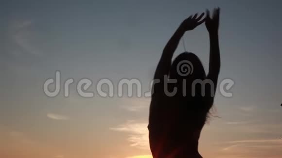 美丽的日落时分比基尼女孩的剪影在海滩上翩翩起舞1920x1080高清视频的预览图