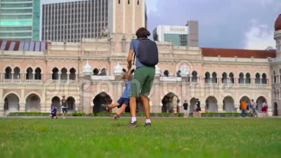 马来西亚吉隆坡梅德卡广场上一名父亲绕着儿子转的慢镜头视频的预览图