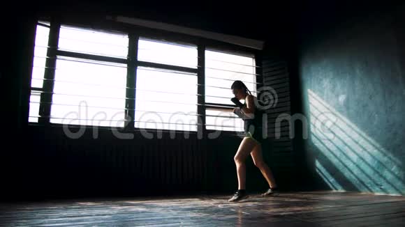 剪影美丽的年轻拳击女子训练拳击健身室慢动作视频的预览图