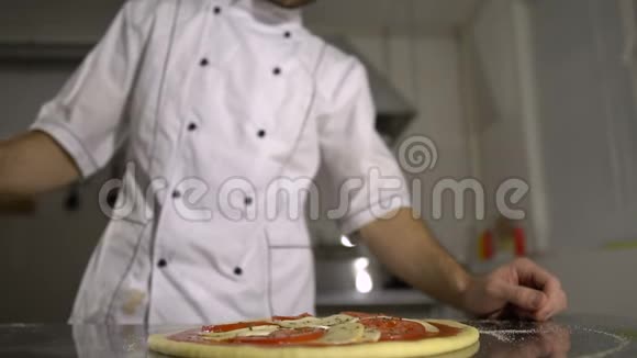 厨师把香料洒在厨房里的披萨上视频的预览图