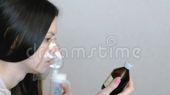 使用雾化器和吸入器进行治疗特写女人她的脸通过吸入面罩吸入侧视视频的预览图