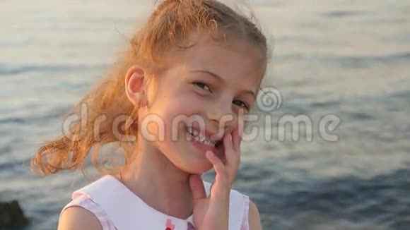 可爱的小女孩在大海的背景下笑视频的预览图