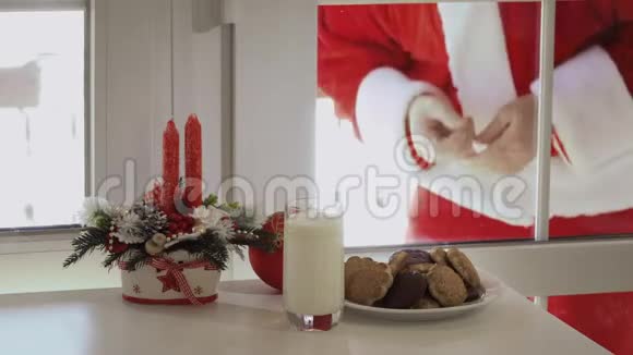 圣诞老人想品尝牛奶和饼干透过玻璃看视频的预览图
