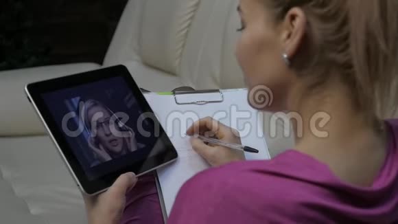 女人正在平板电脑上看网络研讨会远程教育概念家庭在线教育慢动作视频的预览图