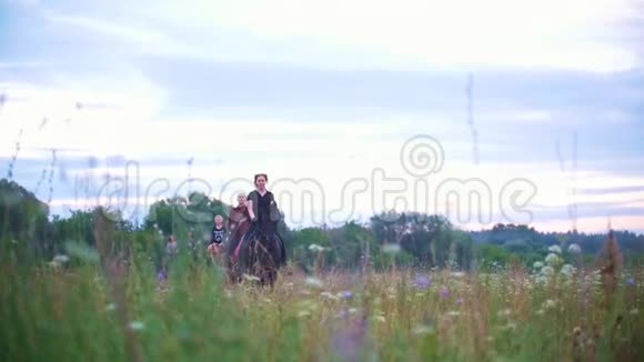 一群骑马的年轻人带着鲜花穿过草地视频的预览图