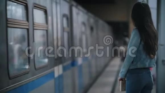 女孩环顾四周站在站台上经过火车慢动作视频的预览图