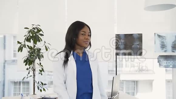 身着白衣的女医生对着医院里的镜头微笑的画像视频的预览图
