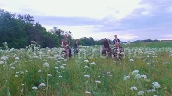 年轻人骑着马带着夏日的鲜花穿过草地视频的预览图