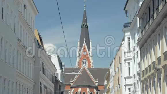 在欧洲城市狭窄的街道上的建筑物之间的教堂挂着电线视频的预览图