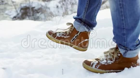 在深雪中行走的脚以慢动作射击徒步旅行者的脚步在美丽的风景中展现年轻人视频的预览图