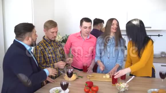 一群朋友聚集在厨房吃晚饭准备晚餐的朋友视频的预览图