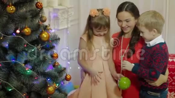 母亲和孩子们装饰圣诞树幸福家庭视频的预览图