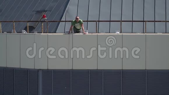 一个人站在摩天大楼的屋顶上向下看视频的预览图