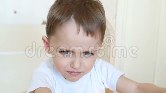 一个特写的孩子看着镜头皱着眉头男孩表现出不满失望消极情绪关闭视频的预览图