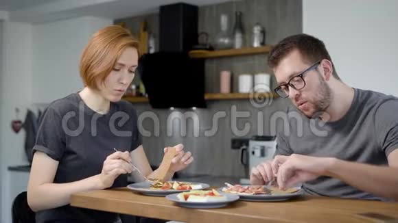 夫妻一起吃早餐木条后面现代厨房内部后面视频的预览图
