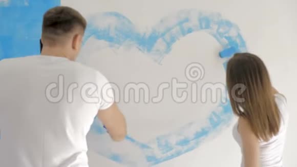 一家人用蓝色油漆把心画在墙上快乐日概念视频的预览图