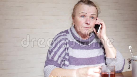 奶奶坐在餐桌旁打电话视频的预览图