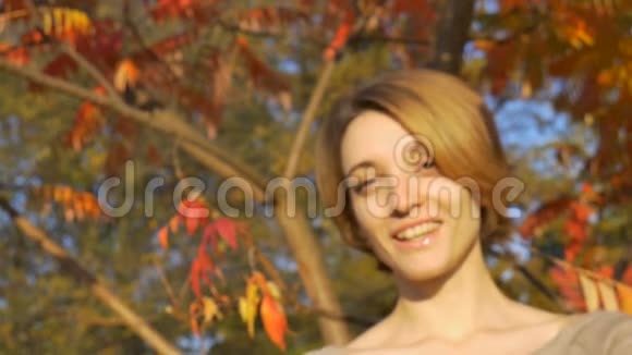 金黄短发的小女孩在秋天阳光明媚的天气里拿着一把竹制牙刷在户外视频的预览图