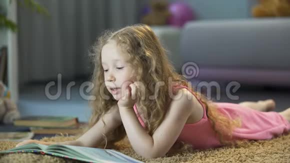 聪明的小女孩独自在家看最喜欢的书快乐的童年视频的预览图