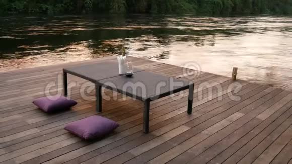 4K镜头黄昏时在河边休息以水流为背景的休闲座椅视频的预览图