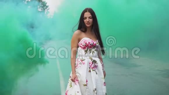 穿着长裙的可爱女孩在彩色烟雾中漫步视频的预览图