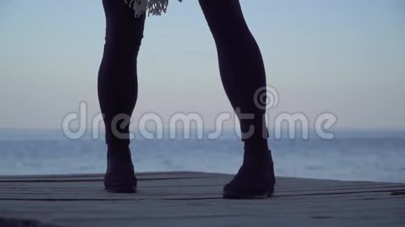女性的腿在户外的木制平台上跳舞穿紧身裤和靴子的女人的腿视频的预览图