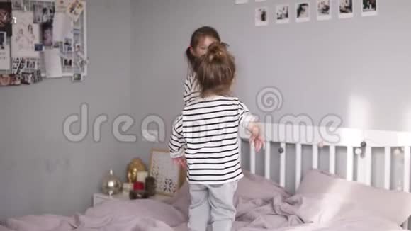 两个小姐姐在一张床上跳然后摔倒在上面微笑的脸慢动作视频的预览图