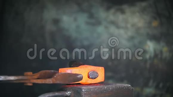 铁匠用电锤在铁砧上工作工人用红热钢打洞工艺视频的预览图