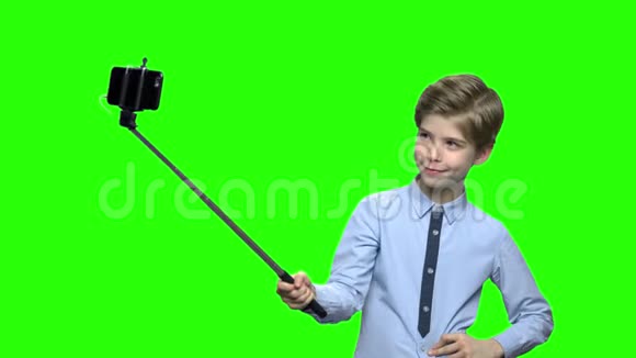 男孩与自拍棒显示无花果在相机上视频的预览图