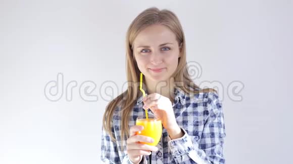 美丽的女孩用吸管喝新鲜的橙汁视频的预览图