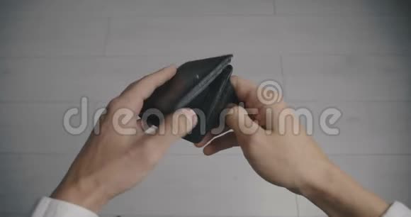 一个男人的特写手拿着皮钱包空无钱贫穷的概念视频的预览图