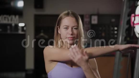 有一个漂亮身材的运动女人在训练前做伸展运动视频的预览图