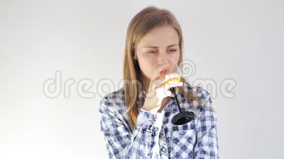 女孩喝着新鲜橙汁看着镜头视频的预览图