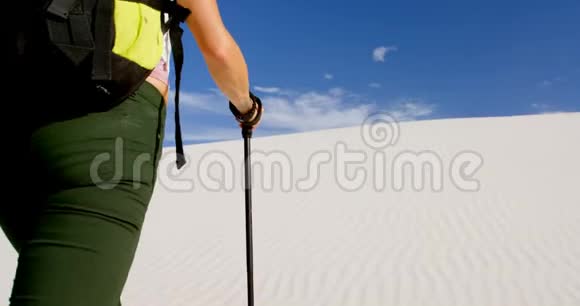 带着登山杆在沙漠中行走的女人视频的预览图