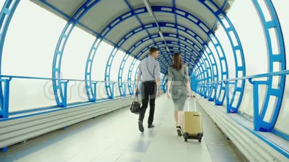 后景商业伙伴一男一女在车站或机场的终点站携带行李商务视频的预览图