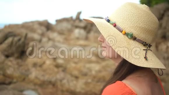 漂亮的女人独自坐在海边的石滩上视频的预览图