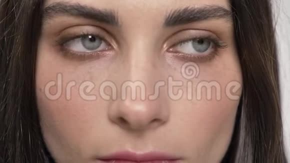 蓝眼睛直视镜头闭眼的年轻美女肖像白色背景视频的预览图