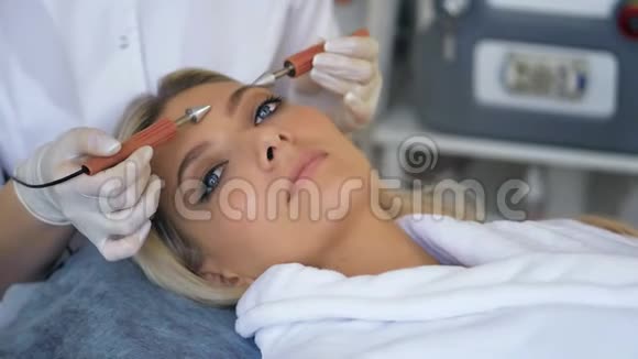 在碧蒂沙龙接受治疗师面部微电流治疗的美女特写视频的预览图
