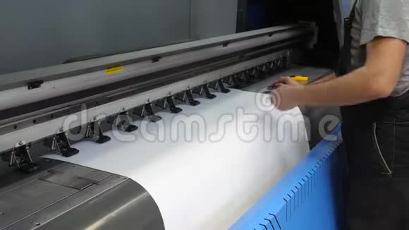 大型喷墨印刷机的准备工人的男性手把干净的印刷纸插入视频的预览图